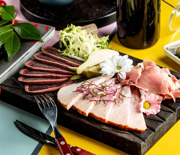 Bandeja antipasto de carne con jamón y pera en rodajas de salami de pavo — Foto de Stock