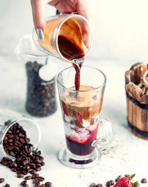 Kvinna hälla kaffe skjuten i jordgubbssirap mix med glass — Stockfoto