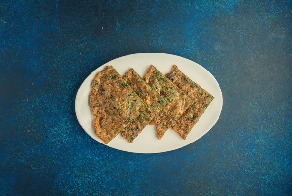 Kuku kookoo çırpılmış yumurta, kişniş ve dereotla pişirilir.