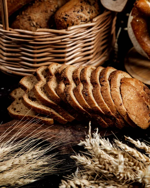 Sliced bread and wheat on the table — Stock Photo, Image