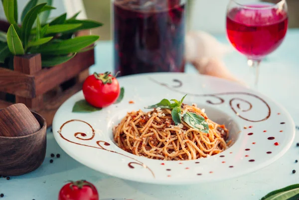 Espaguetis boloñés en plato blanco con bebida rosa —  Fotos de Stock