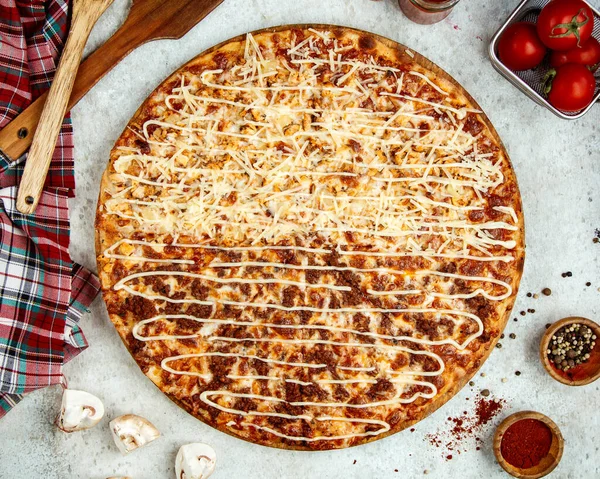 meat pizza with half covered in extra grated cheese