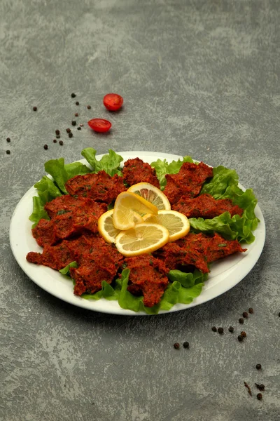 Bir tabak hindi chig kofte çiğ köfte ile domates ezmesi ve baharat.