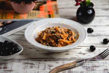 sığır eti, zeytin, domates sosu ve rendelenmiş peynirli fettuccini.