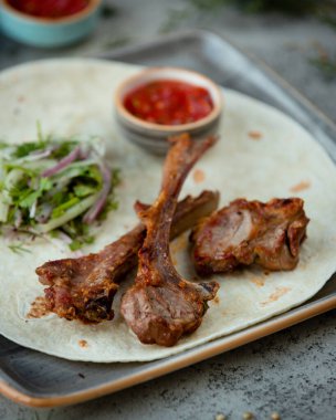 Izgara kuzu pirzola, salatayla servis edilen pirzola.