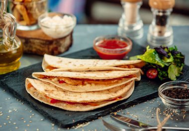 Renkli dolmalık biberli tavuk fajitaları, domates, sos ve salata.