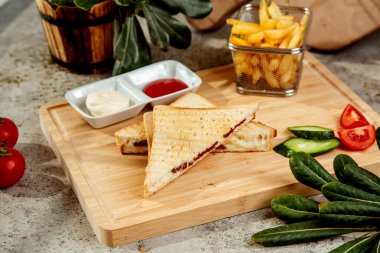 toast with salami and cheese served with french fries and sauces