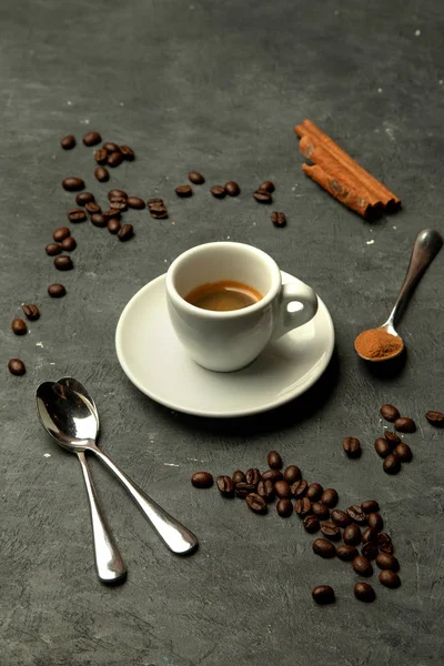 Glass of espresso coffee in grey background decorated with coffee beans — Stock Photo, Image