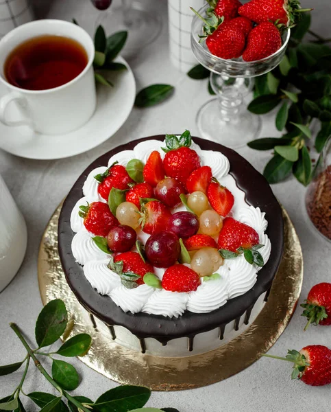 Draufsicht auf Schokoladentropfkuchen mit Erdbeere und Trauben — Stockfoto