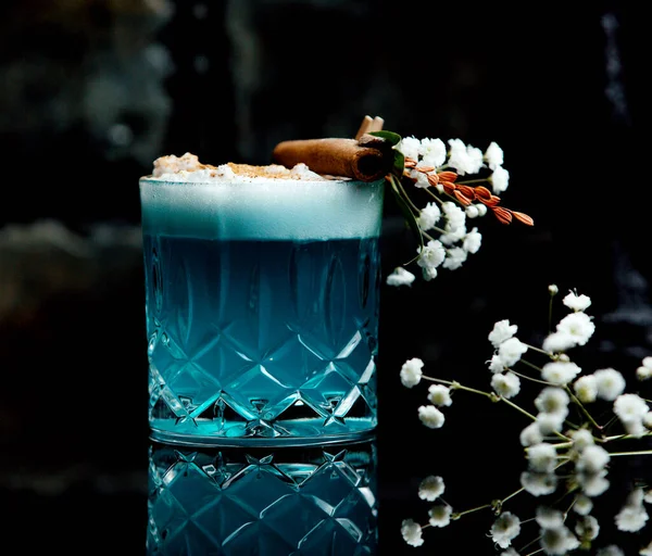 青いラグーンの結晶ガラスはシナモンスティックで装飾された飲み物 — ストック写真