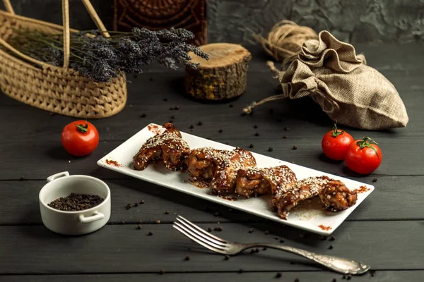 Kippenvleugels gekookt in teriyaki saus versierd met sesam — Stockfoto