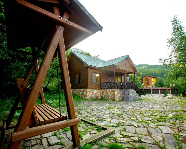 Дерев'яний будинок з верандою і дерев'яними гойдалками — стокове фото