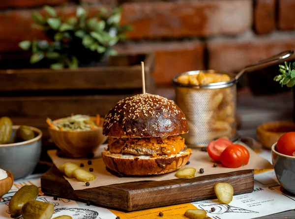 burger with chicken herbs patty served with fries, coleslaw and pickles