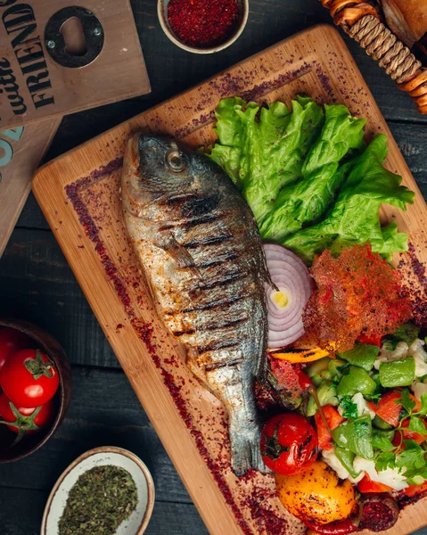 Pescado a la parrilla con ensalada de verduras, cebolla y zumaque —  Fotos de Stock