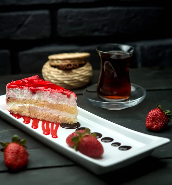 Σιρόπι φράουλας τούρτα σφουγγάρι κρέμα και ένα φλιτζάνι αρωματισμένο τσάι — Φωτογραφία Αρχείου