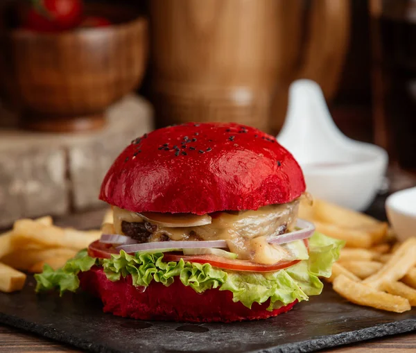 Крупним планом червоний бургер з салатом, цибулею, розтопленим сиром — стокове фото