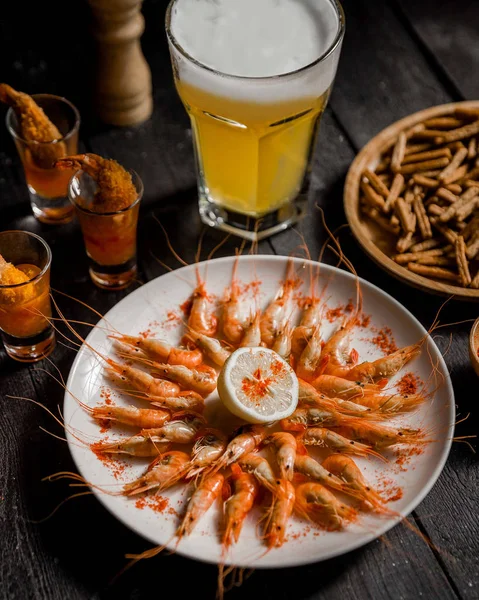 Vařené krevety s citrónem a sklenicí studeného piva — Stock fotografie