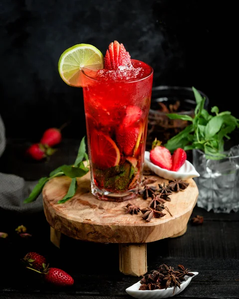 A glass of strawberry cocktail with strawberry and lime slices — Stock Photo, Image