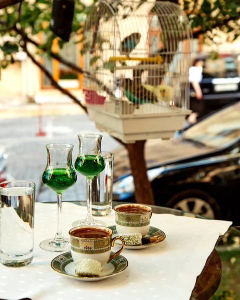 Two cups of turkish coffee and two glass of green fizzy drink served at the restaurant garden — Stock Photo, Image