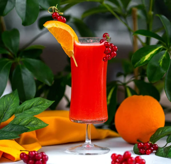 Coquetel vermelho decorado com cranberry e fatia de laranja — Fotografia de Stock