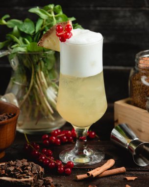 Köpüklü soğuk içecek ve bir dilim ananas ve kızılcık.