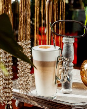 a glass of foamy latte with three layers