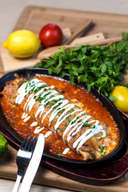 Kremayla süslenmiş domates soslu ıslak burrito.