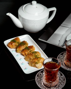 Armudu dilinde siyah çay ve Türk pakhlava.