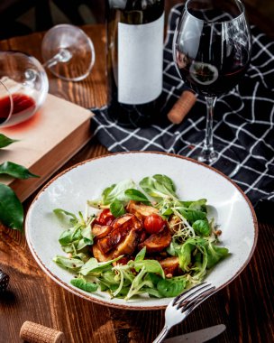 Taze sebzeli kızarmış patates ve kırmızı şarap.