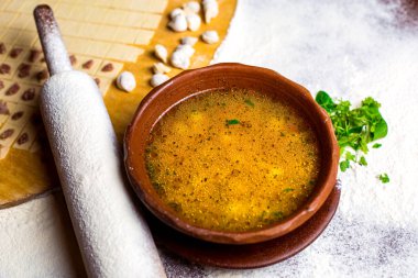 Merdanenin yanında bir kase dushbara hamur çorbası.