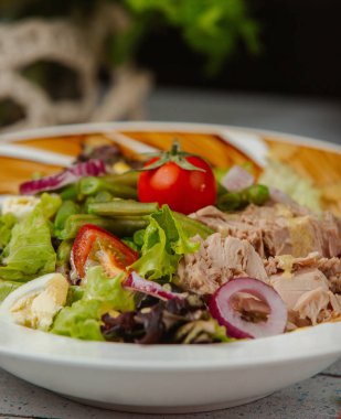 Soğanlı, domatesli, marullu ve yumurtalı ton balığı salatası.