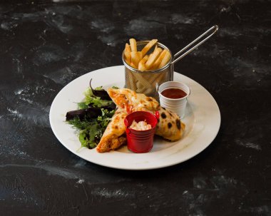 Kızarmış patates, yeşillik ve ketçapla servis edilen sebze krepleri.