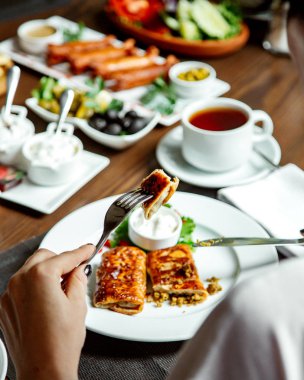 gözleme ve bir fincan çay ile çeşitli yiyecekler.