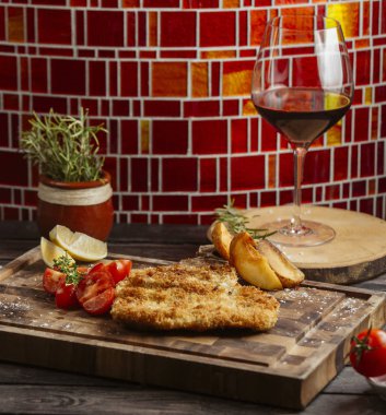 Tahta 1 'de domates ve kızarmış patatesle servis edilen kızarmış tavuk.