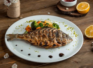 fried fish with vegetables in the plate __