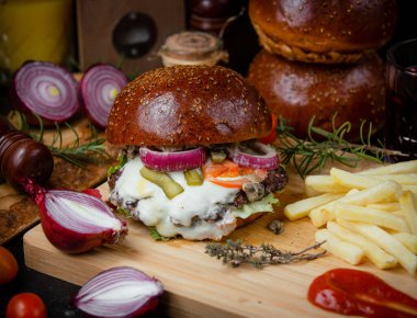 Tahtada kızarmış patates ve soğanlı çizburger.