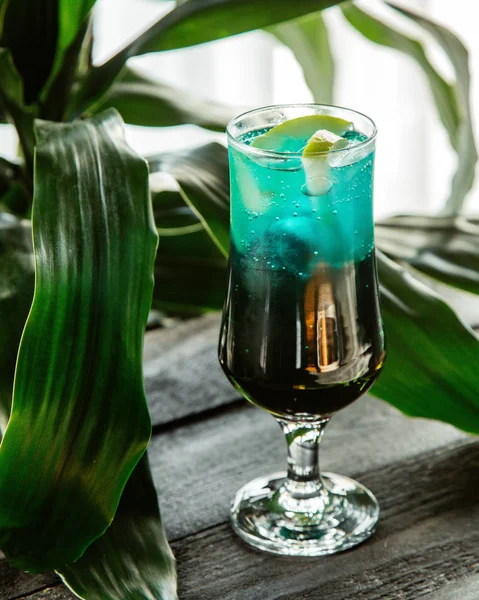A glass of green cocktail garnished with apple slice — ストック写真