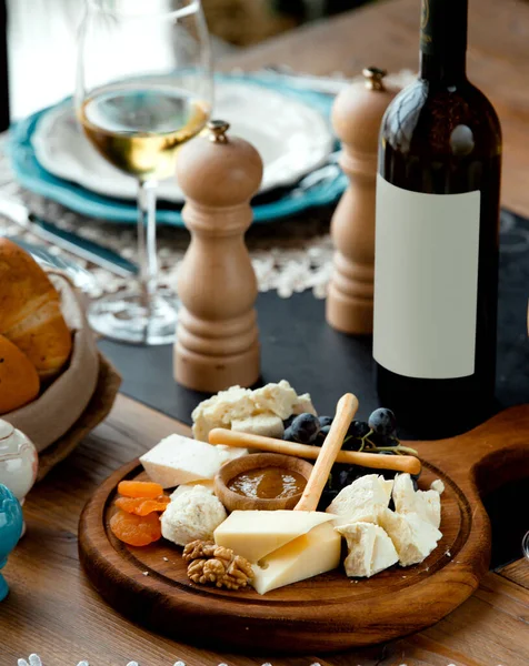Set de quesos con vino tinto sobre tabla de madera — Foto de Stock