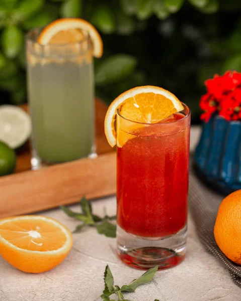 Een glas rood sap gegarneerd met sinaasappelschijfje — Stockfoto