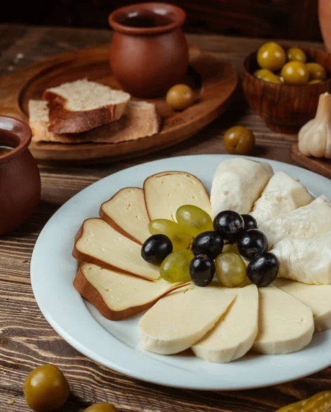 Traditional setup for cheese plate with smoked, white, goat cheese, grapes — Stock Photo, Image