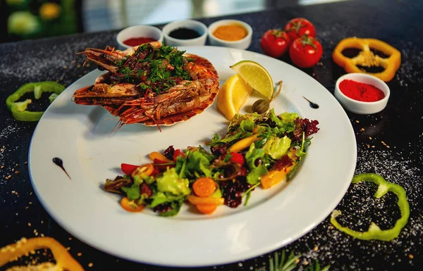 Gebakken tijgergarnaal geserveerd in schelp naast verse groenten salade en citroen — Stockfoto