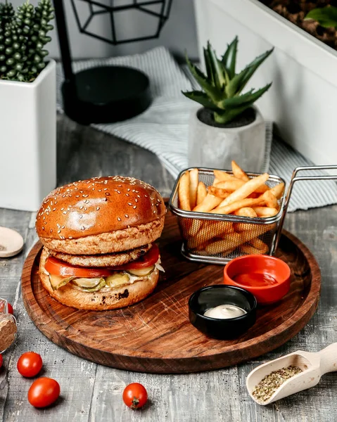 Hambúrguer com batatas fritas em mesa de madeira — Fotografia de Stock