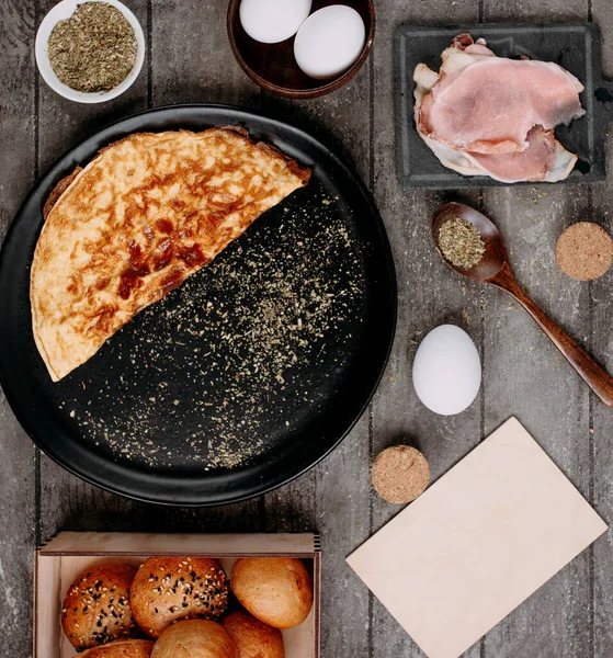 Omelet in pan en kant rauwe becons — Stockfoto