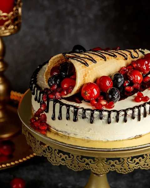 Close up of chocolate dripping cake topped with wrapped waffle with berries — ストック写真
