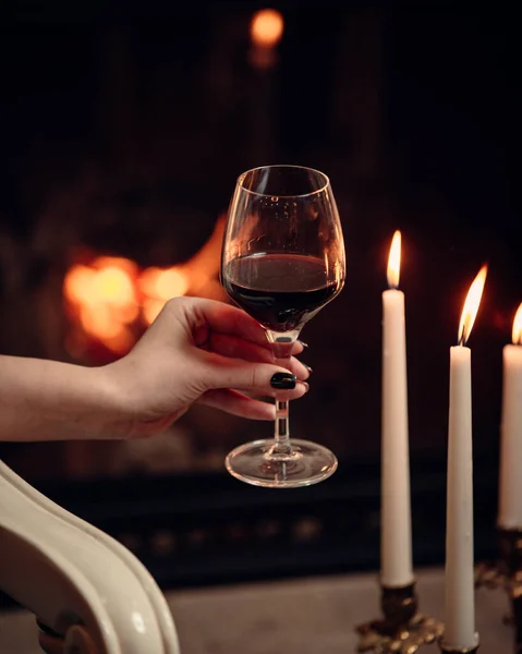 Um copo de vinho tinto cercado de velas em atmosfera romântica — Fotografia de Stock