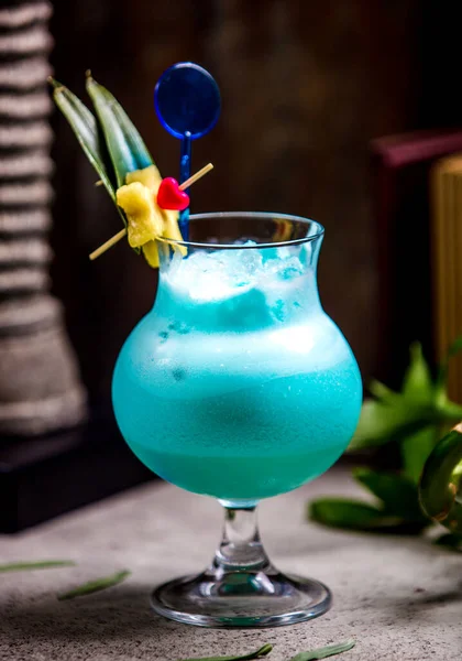 Üzerinde yapraklar ve meyveler olan mavi bir kokteyl. — Stok fotoğraf