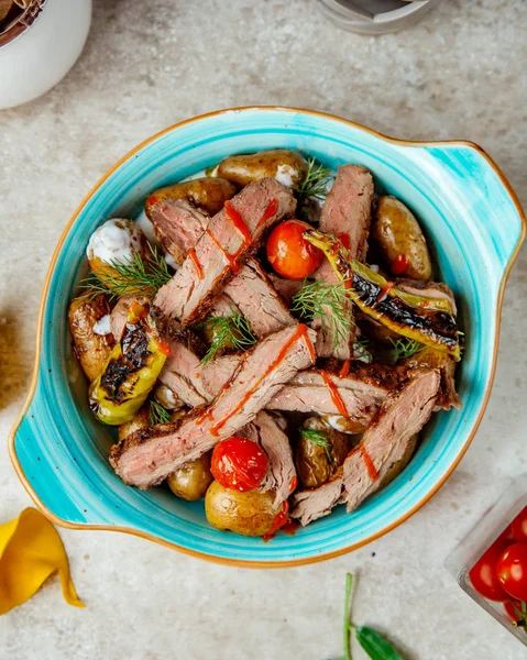 Bakat kött och potatis i ugnen med tomater och paprika ovanifrån — Gratis stockfoto
