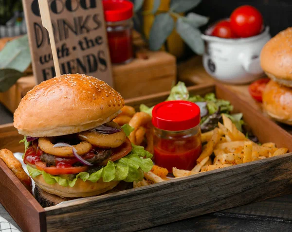 Hamburger with onion rings and fries