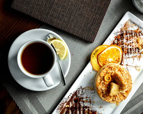 Апельсиновый пирог и чашку черного чая с ломтиком лимона — стоковое фото