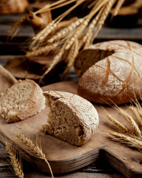 Organic brown bread slice placed on wooden board in rustic style — Stock Photo, Image